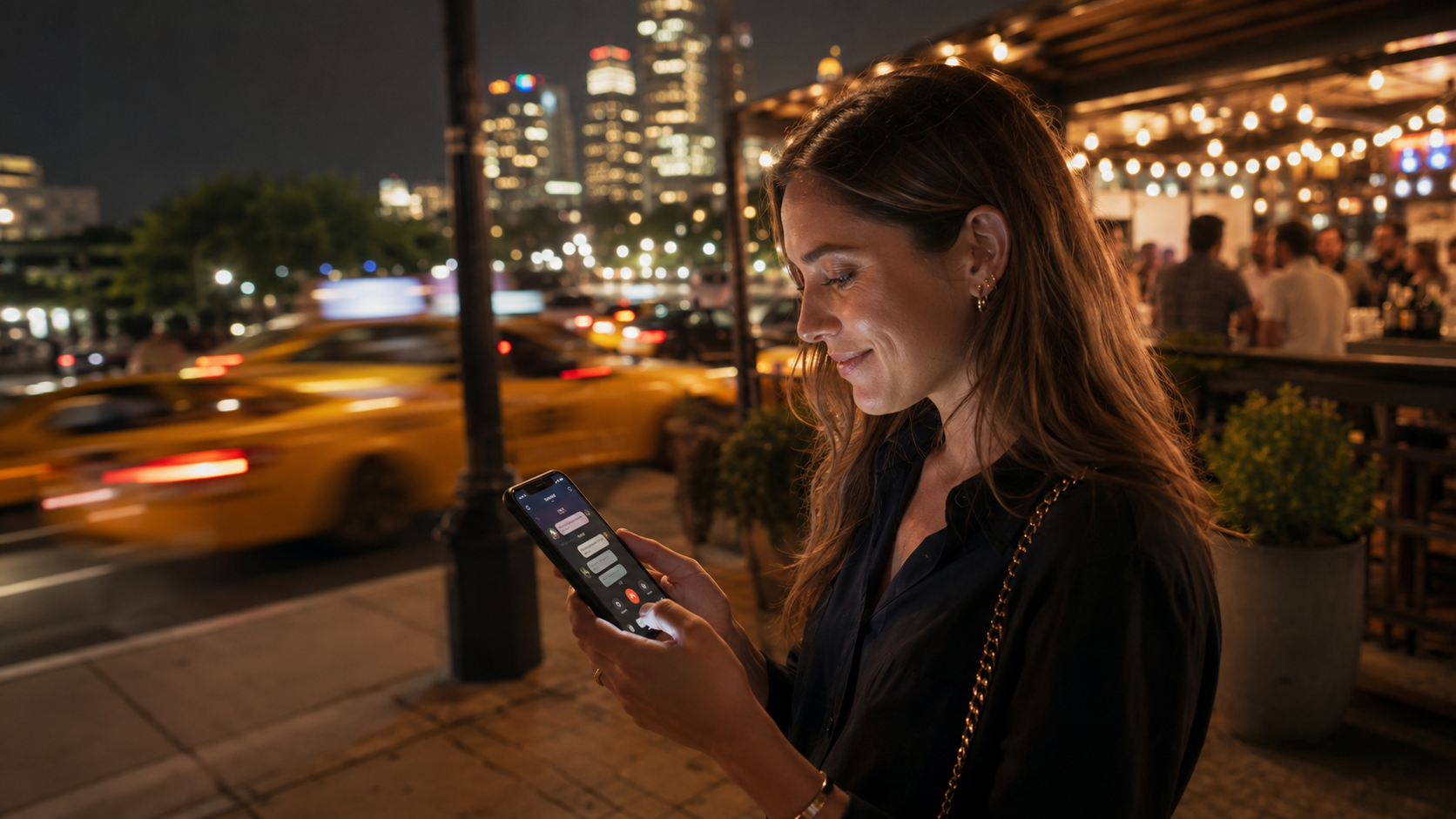 Young woman outside a crowded bar at night using captioned calling on her smartphone to read the call